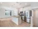 Open concept kitchen featuring stainless steel appliances, island, and hardwood floors at 2032 S Holly St # 3, Denver, CO 80222