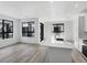 Bright kitchen with white cabinets, quartz countertops, stainless appliances, and large windows at 2032 S Holly St # 3, Denver, CO 80222
