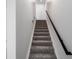 Staircase with carpeted steps and a dark wood handrail, leading to the upper level at 2032 S Holly St # 3, Denver, CO 80222