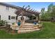 Beautiful backyard with a stone patio, pergola, outdoor seating and fireplace feature at 6122 Maroon Peak Pl, Castle Rock, CO 80108
