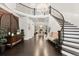 Grand foyer with soaring ceilings, a curved staircase, dark wood floors, and elegant decor at 6122 Maroon Peak Pl, Castle Rock, CO 80108