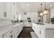 Modern kitchen with white cabinetry, stainless steel appliances, and a large center island with gas cooktop at 6122 Maroon Peak Pl, Castle Rock, CO 80108