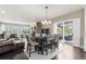 Open-concept living and dining area with a stone fireplace, hardwood floors, and sliding glass doors to the backyard at 6122 Maroon Peak Pl, Castle Rock, CO 80108