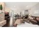 Bright and open floor plan featuring a living room with leather furniture, stone fireplace, and view of dining area at 6122 Maroon Peak Pl, Castle Rock, CO 80108
