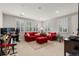 Inviting living room features large windows, comfortable red sofas, and stylish decor at 6122 Maroon Peak Pl, Castle Rock, CO 80108