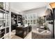 Elegant home office with a large desk, bookshelves, comfortable seating, and bright natural light at 6122 Maroon Peak Pl, Castle Rock, CO 80108