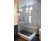 Walk-in shower with glass enclosure, marble tile, and built-in seat at 5695 Cadara Way, Parker, CO 80134