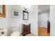 Cozy half-bathroom with a pedestal sink, framed artwork, and wood-look floors, accented by a decorative light fixture at 954 E Costilla Ave, Centennial, CO 80122
