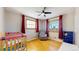 Inviting bedroom features windows allowing natural light, a crib, and a comfortable chair at 954 E Costilla Ave, Centennial, CO 80122