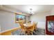 Dining room boasts a wooden table, chairs, and a large window offering an outside view, beneath a stylish chandelier at 954 E Costilla Ave, Centennial, CO 80122