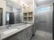 A bathroom featuring a double vanity, glass enclosed shower, and light color palette at 11659 W 44Th Ave, Wheat Ridge, CO 80033