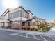 Row of modern townhomes featuring neutral siding, brick accents, and well-maintained landscaping under a clear sky at 11659 W 44Th Ave, Wheat Ridge, CO 80033