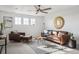 Inviting living room with plush seating, a ceiling fan, and sunburst mirror, offering a comfortable retreat at 270 Maddox Ln, Erie, CO 80516