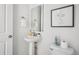 Chic powder room with a pedestal sink, modern mirror, and stylish wall art, maximizing space and elegance at 270 Maddox Ln, Erie, CO 80516