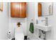 Powder room featuring a toilet, floating sink, and a wood cabinet for storage at 831 Crescent Dr, Boulder, CO 80303
