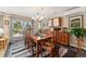 Sunlit dining room with modern chandelier, wood table set, and sliding glass door at 831 Crescent Dr, Boulder, CO 80303