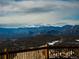 Expansive mountain view from a wood deck with snow-capped peaks and rolling hills at 13589 Callae Ct, Conifer, CO 80433