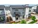 Modern townhome featuring a gray and white exterior, balcony, and well-maintained landscaping at 2052 Alcott Way, Broomfield, CO 80023
