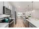 Bright kitchen with stainless appliances, gray cabinets, a large island, and white subway tile backsplash at 2052 Alcott Way, Broomfield, CO 80023