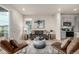 Open concept living room with modern furnishings, hardwood floors, and large windows providing natural light at 2052 Alcott Way, Broomfield, CO 80023