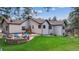 Expansive backyard featuring a lush lawn, stone patio, and a cozy fire pit area for outdoor enjoyment at 1151 Kenosha Dr, Larkspur, CO 80118