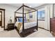 This primary bedroom features a large window, a four poster bed, and tasteful decorations at 1151 Kenosha Dr, Larkspur, CO 80118