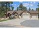 Beautiful home exterior featuring a manicured lawn, stone accents, and ample parking space at 1151 Kenosha Dr, Larkspur, CO 80118