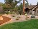 Manicured front yard with garden beds and a lush green lawn at 1151 Kenosha Dr, Larkspur, CO 80118