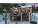 Two-story house with large deck, hot tub, and snowy landscape at 1151 Kenosha Dr, Larkspur, CO 80118