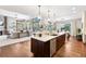 Modern kitchen with a large island, stainless steel appliances, and hardwood floors at 1151 Kenosha Dr, Larkspur, CO 80118