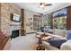 Spacious living room with a stone fireplace, large windows, and comfy seating at 1151 Kenosha Dr, Larkspur, CO 80118