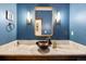 Elegant powder room with a vessel sink and blue walls at 1151 Kenosha Dr, Larkspur, CO 80118