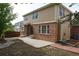 Exterior backyard view with a concrete patio, brick accents, and two-story home with neutral siding at 20630 E Hamilton Ave, Aurora, CO 80013