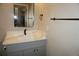 Bathroom features a gray vanity with modern hardware and a countertop with updated fixtures at 20630 E Hamilton Ave, Aurora, CO 80013