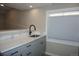 Kitchenette featuring shaker cabinets with black pulls, a marble countertop, and a modern black faucet at 20630 E Hamilton Ave, Aurora, CO 80013