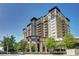 Modern, multi-story condo building with balconies, trees and commercial space at 5455 Landmark Pl # 1403, Greenwood Village, CO 80111