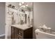 Bright bathroom with a dark cabinet, sink, mirror, overhead lighting, toilet and neutral wall color at 7021 S Eudora St, Centennial, CO 80122