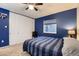 Bedroom with carpet flooring, dark blue accent wall, ceiling fan, and a window at 7021 S Eudora St, Centennial, CO 80122