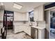 Well-lit kitchen boasts white cabinetry, stainless steel appliances, and a view into the adjacent dining area at 7021 S Eudora St, Centennial, CO 80122