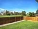 Private backyard with lush green grass and beautiful golf course views beyond the fence at 8403 Chase Dr, Arvada, CO 80003