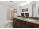 Bathroom with a double sink vanity with granite countertops and a tub with shower at 8403 Chase Dr, Arvada, CO 80003