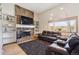 Cozy living room with a stone fireplace, built-in shelves, and comfortable leather seating at 8403 Chase Dr, Arvada, CO 80003