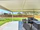 Covered patio with comfortable seating overlooking the green backyard and golf course at 8403 Chase Dr, Arvada, CO 80003