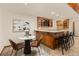 Bar area featuring wood cabinets, granite countertop and seating adjacent to a small dining table at 7570 Windford, Parker, CO 80134