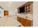Wet bar features wood cabinets, granite countertops, built-in TV, backsplash and ample storage space at 7570 Windford, Parker, CO 80134