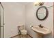 Bathroom featuring pedestal sink, oval mirror, and decorative lighting fixture at 7570 Windford, Parker, CO 80134