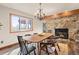 Dining room showcasing a stone fireplace, chandelier, and natural light from a large window at 7570 Windford, Parker, CO 80134