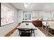 Bright dining area featuring hardwood floors, modern lighting, and large windows with treed view at 7570 Windford, Parker, CO 80134
