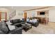 Expansive living room with staircase, featuring stone fireplace and bar area complete with seating at 7570 Windford, Parker, CO 80134