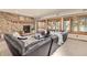 Living room showcases stone fireplace, large black sectional, wood shuttered windows, and sliding doors to the patio at 7570 Windford, Parker, CO 80134